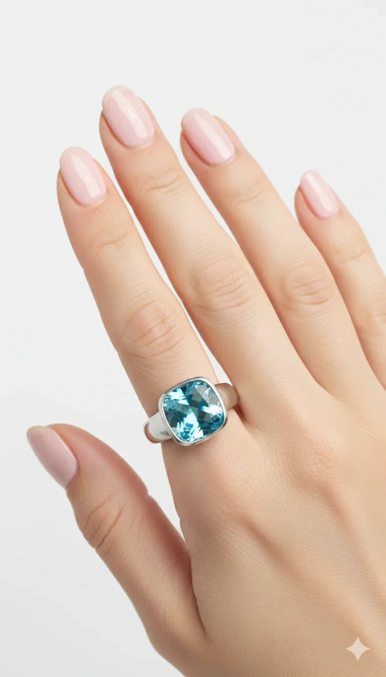 Anello in argento con grande pietra acquamarina su mano femminile con smalto rosa